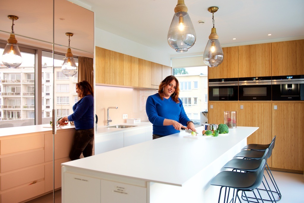 A woman is cooking in the open kitchen in the guesthouse at o2 Clinic.